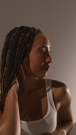 Studio-Beauty-Shot-Of-Young-Woman-With-Long-Braided-Hair-Against-Neutral-Background-In-Profile